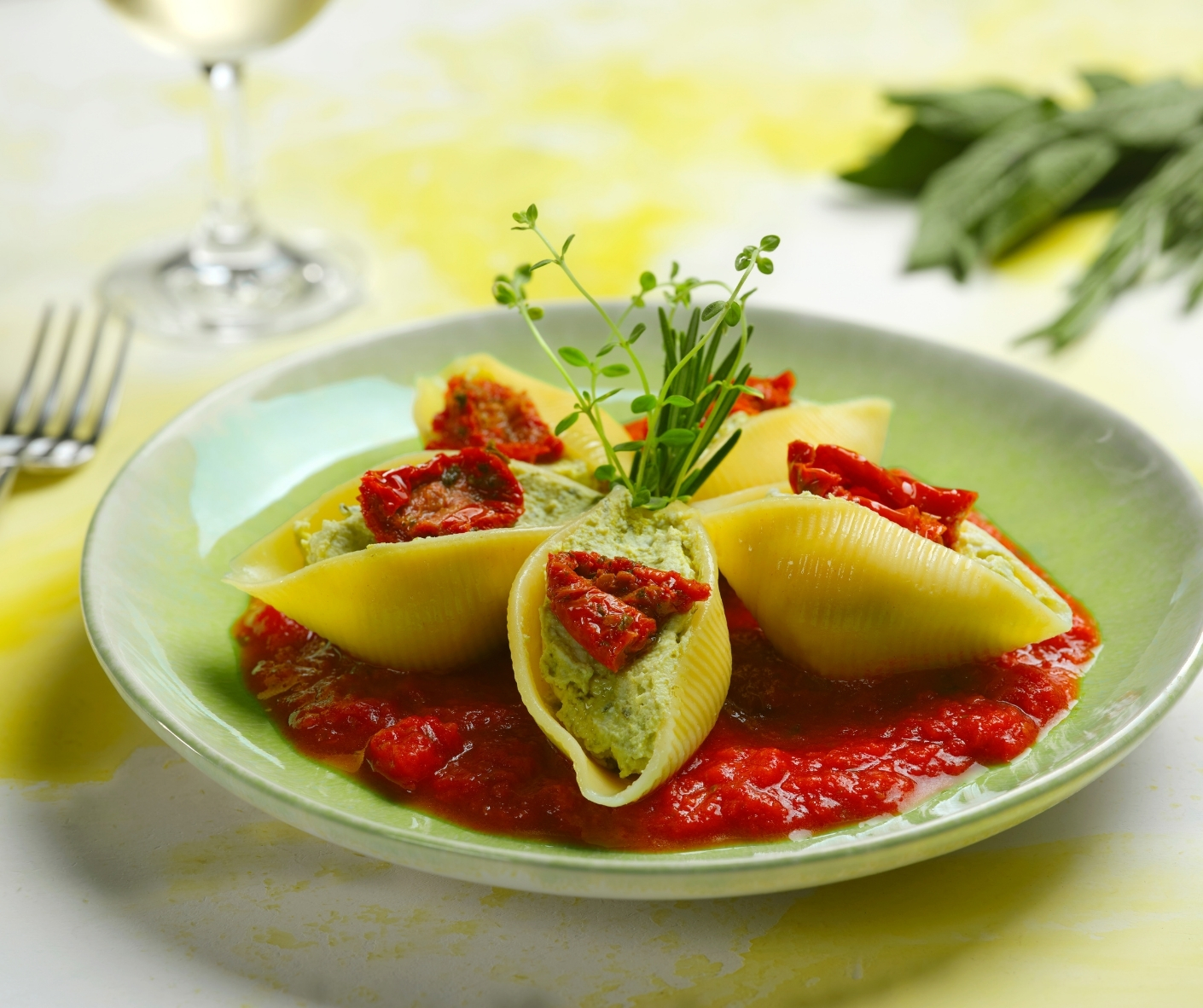 Conchiglioni filled with basil pesto flavored ricotta cheese 