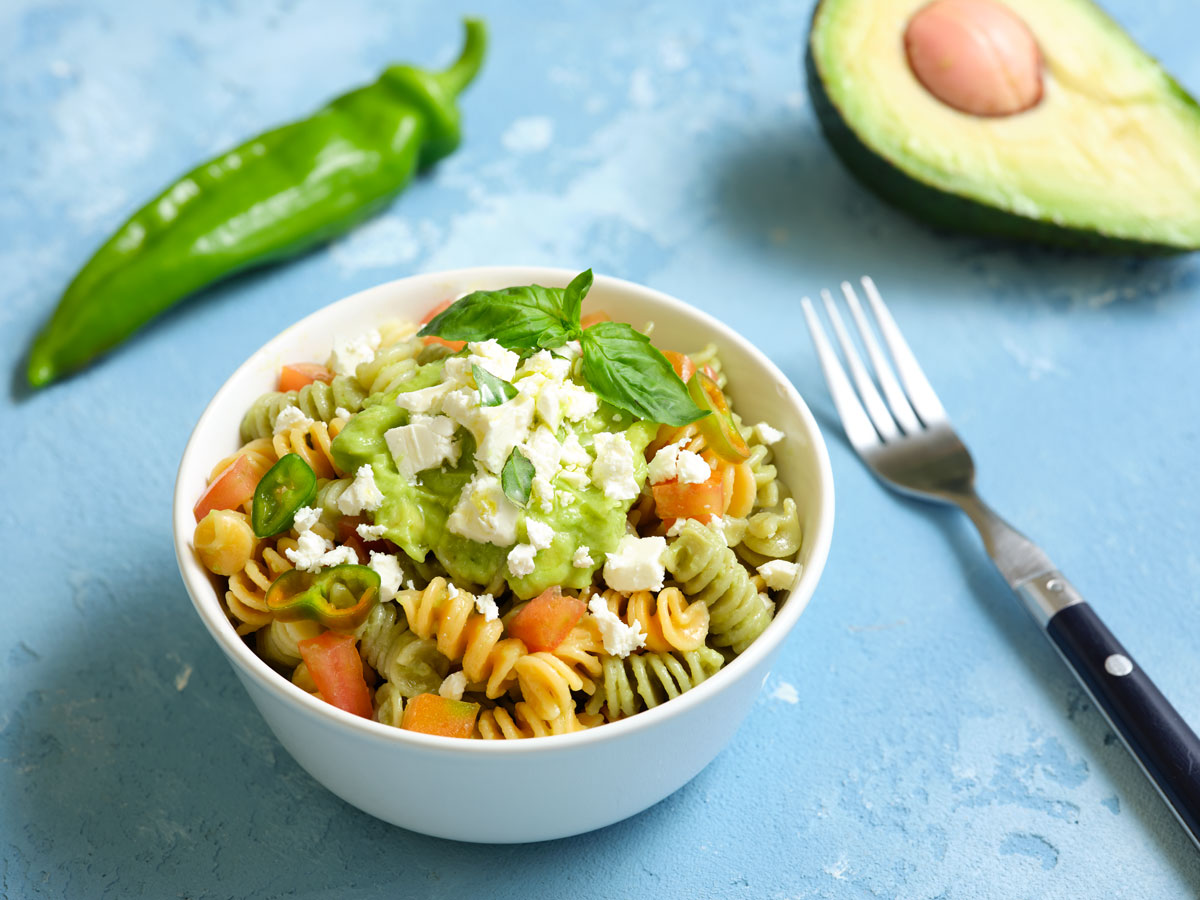 Vegetable fusilli with avocado cream, tomatoes, basil and feta cheese